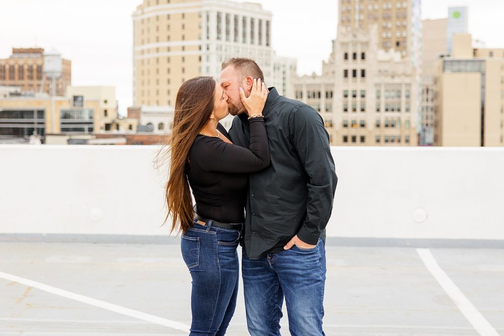 Kissing on rooftop engagement pictures by Sydney Madison Photography